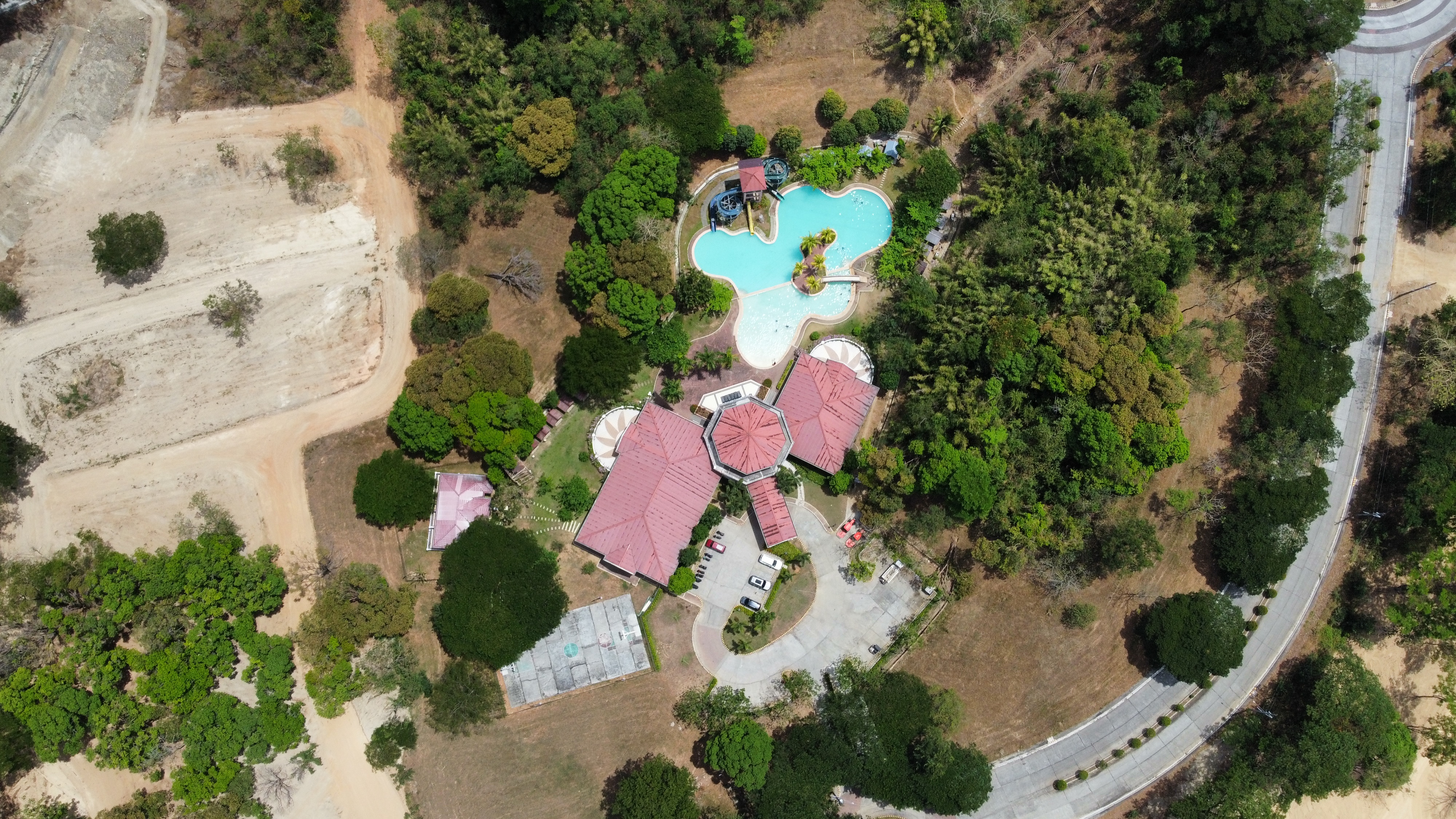 Resort-style swimming pool surrounded by greenery